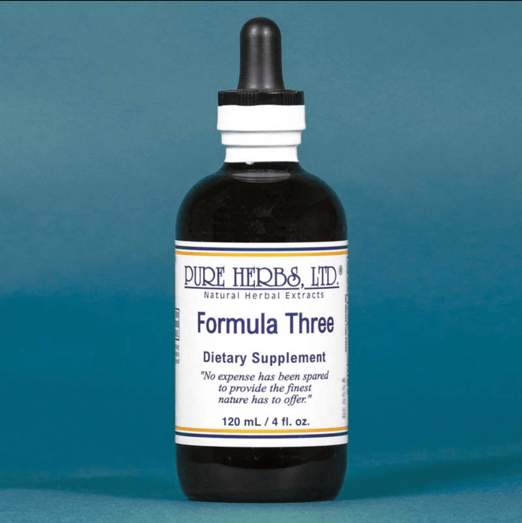 A dark amber glass dropper bottle of Pure Herbs Ltd. Formula Three dietary supplement, featuring a white label with blue text, set against a solid blue background.