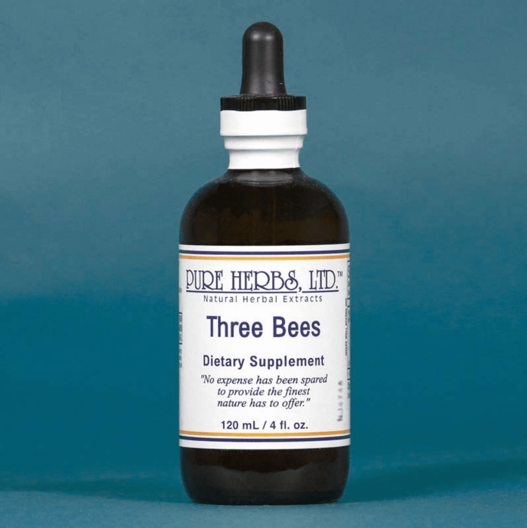A 120 mL amber glass dropper bottle of Pure Herbs Ltd. 'Three Bees' dietary supplement, set against a solid slate blue background.